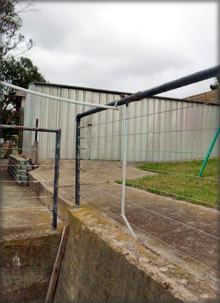 Broken conduit with electric cable lying on metal railing. Potential to electrify handrail!